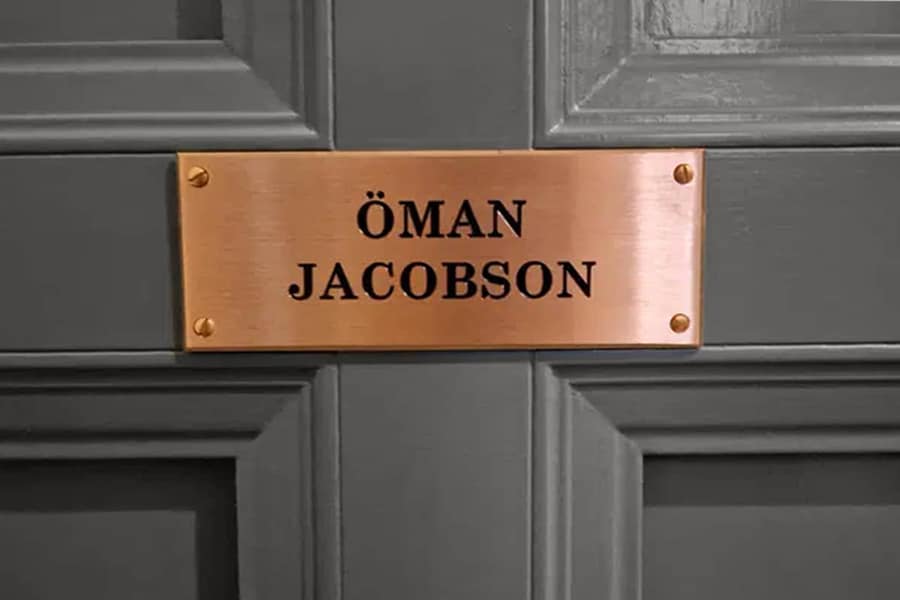 Namnskylt i borstad mässing monterad på dörr
